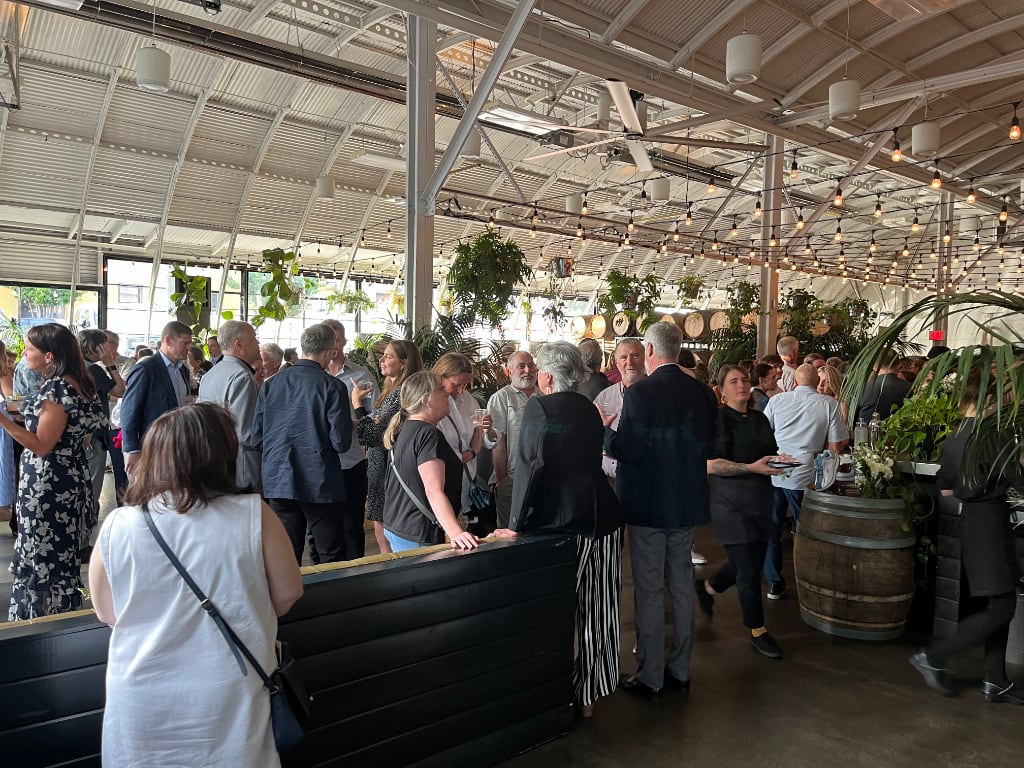 Attendees to a previous LWVSFC convention mill around underneath an outdoor structure.